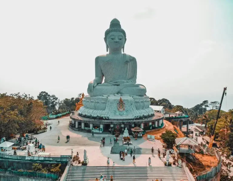 Large Buddha statue overlooking visitors.