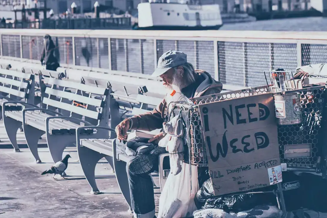 Person sitting with a sign.